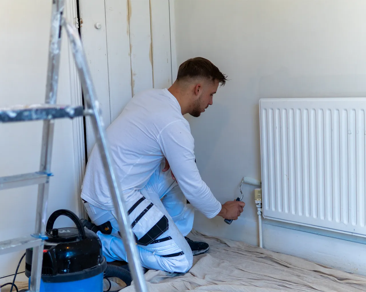 Painter With Roller Painting Wall
