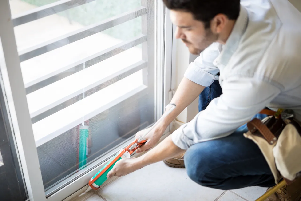 Handyman Applying Some Sealant Door With Sealing Gun